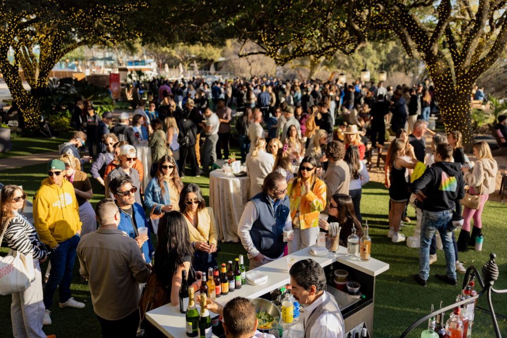 A large crowd of people at a hotel courtyard during SXSW. Photo was taken by a local Austin event coverage team.