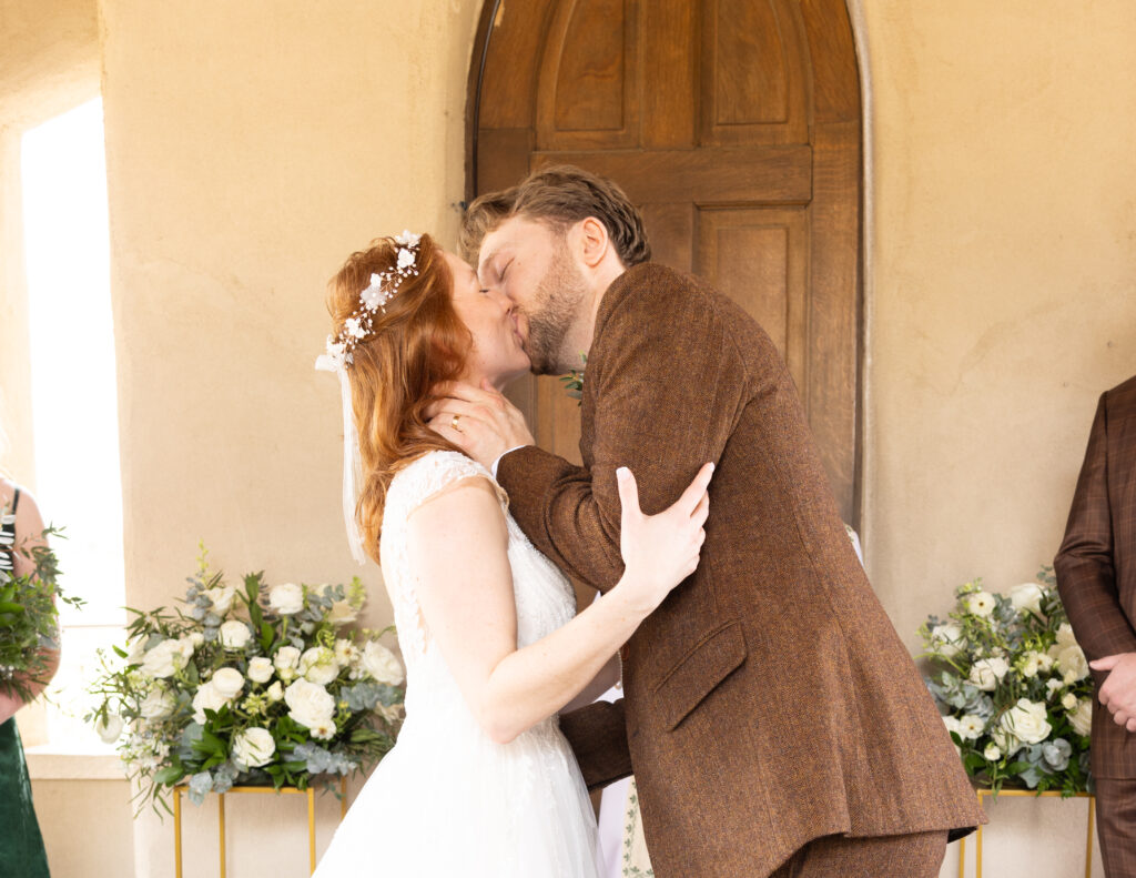Newlywed couple kissing at Chapel Dulcinea. Photo taken by an affordable Chapel Dulcinea photographer